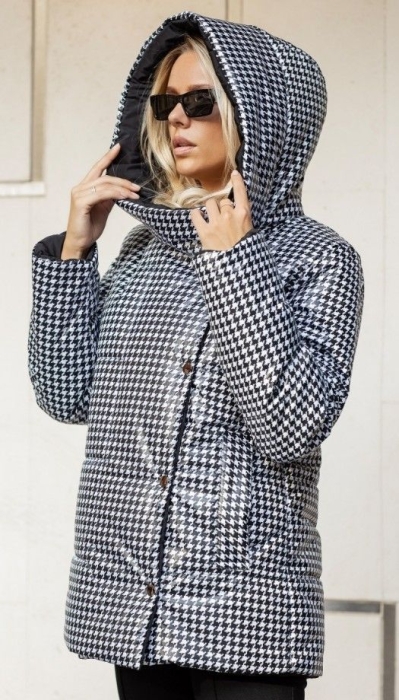 Жінка в куртці з капюшоном із принтом від Шанель, фото