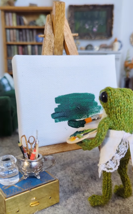 Іграшкова жабка малює картину, фото