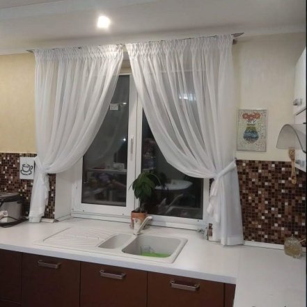 Прозрачные белые занавески на окне кухни.