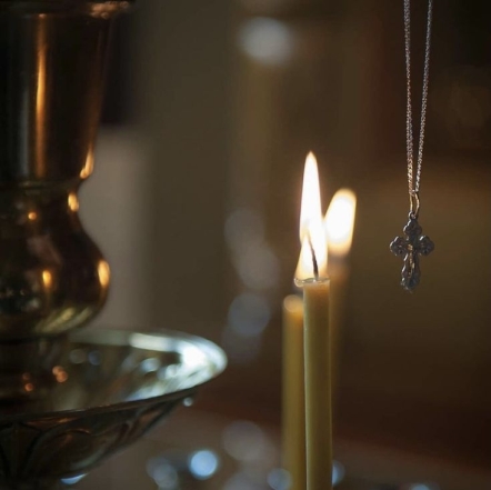 Натільний хрестик і свічки в храмі, фото