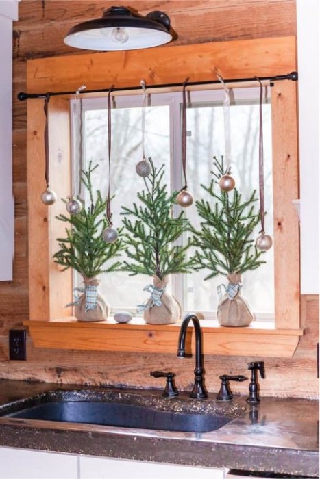 Декор подоконника хвойными ветвями и фонариками на Новый год.