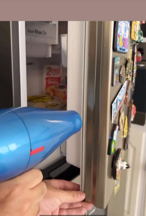 На фото феном прогревают уплотнитель холодильника