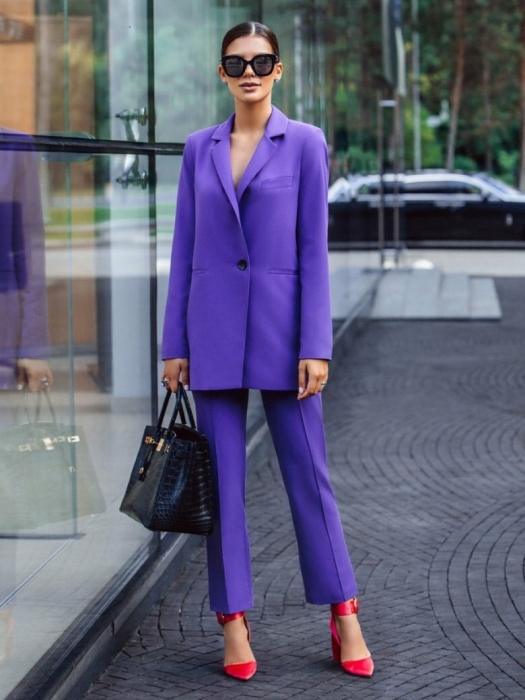 На фото жінка у фіолетовому костюмі