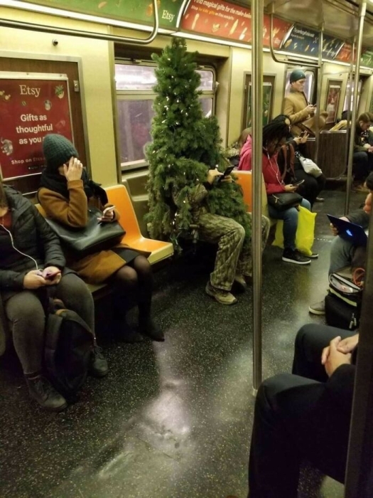 Человек в костюме елки в метро фото