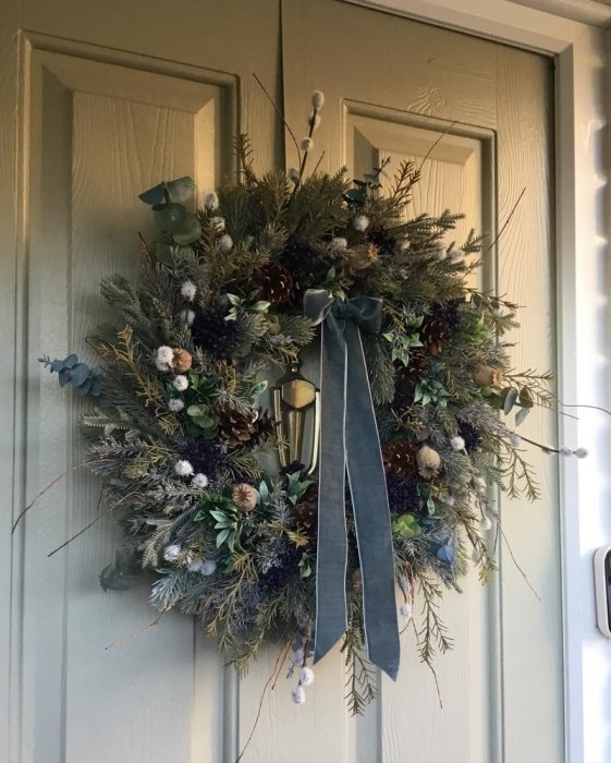 Кріплення різдвяного вінка на двері за допомогою декоративної стрічки