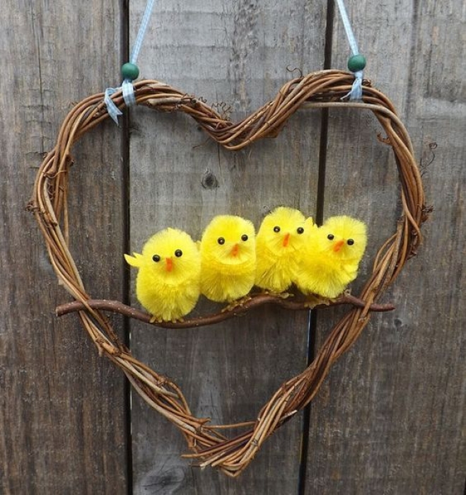 Маленькие игрушечные желтые цыплята в сердечке на ветке, фото