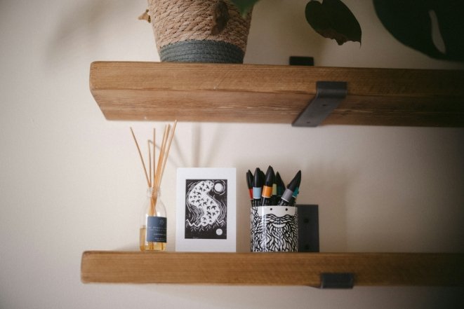 Квіти, освіжувач повітря та картина на полиці