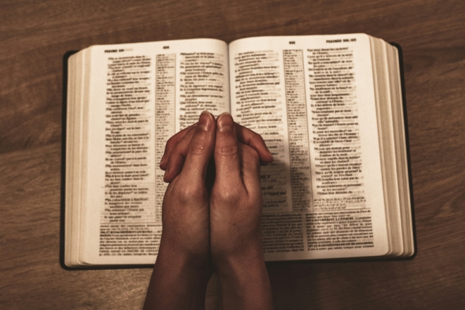 Руки, складені в молитві, на Біблії, фото
