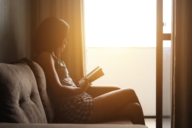 Женщина читает на диване, фото