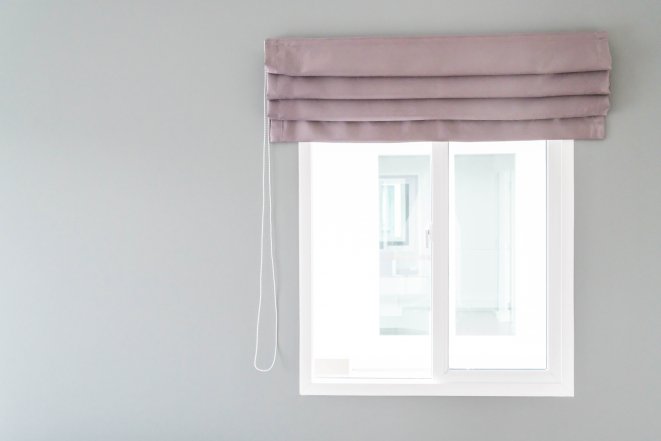 Римские шторы, собранные в аккуратные горизонтальные складки на окне