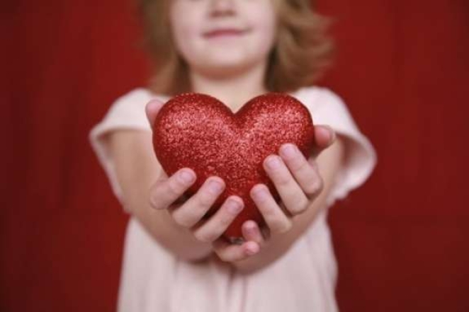 На фото девочка держит фигуру сердца