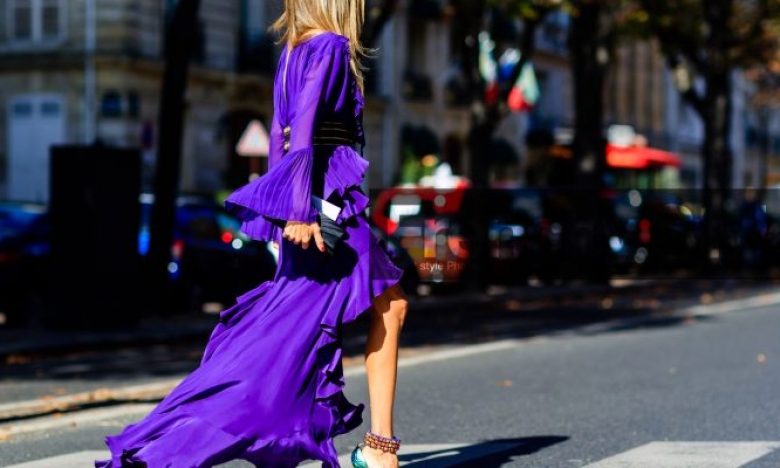 На фото жінка у фіолетовій сукні