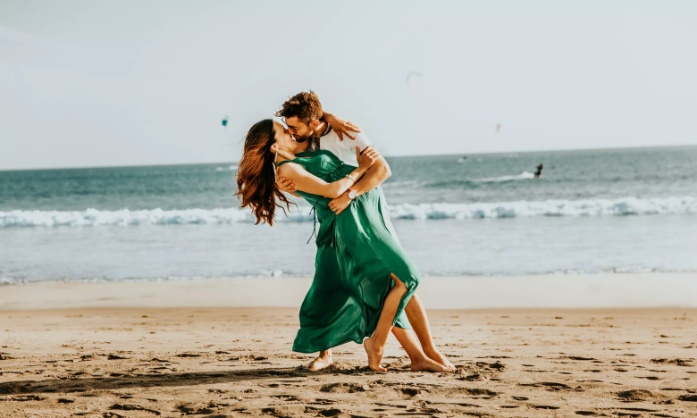 На фото влюбленная пара целуется на пляже