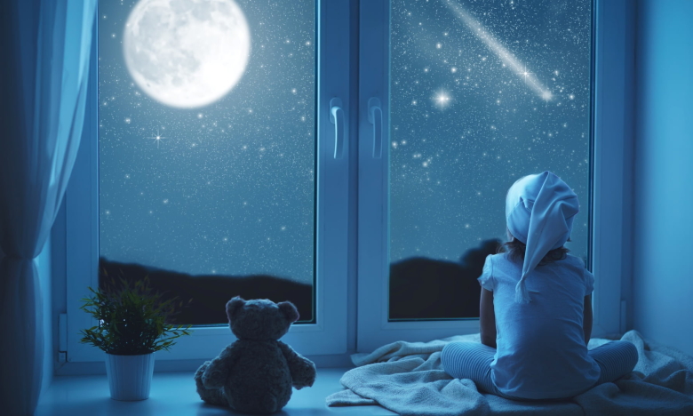 Изображение ребенка, смотрящего в окно ночью