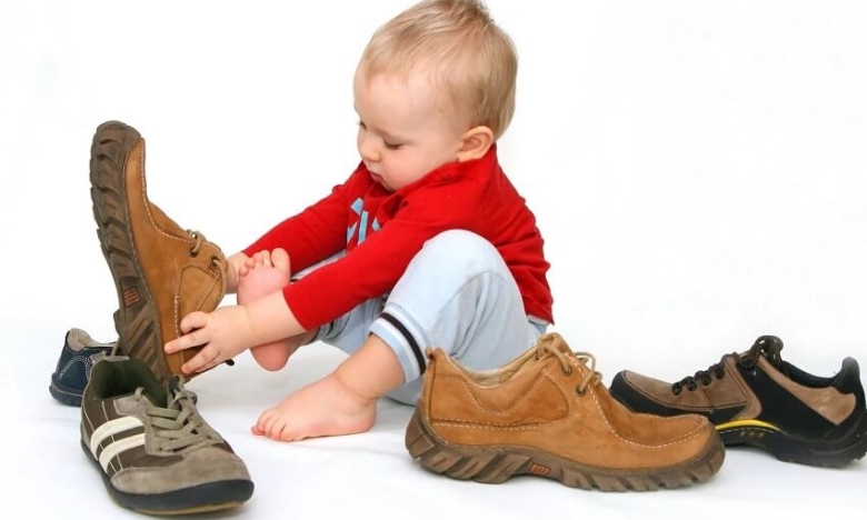 На фото ребенок меряет обувь