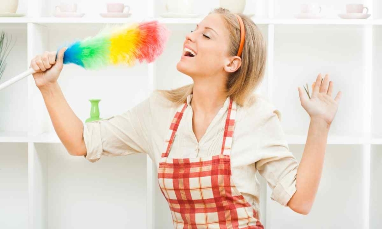 На фото жінка прибирає на кухні