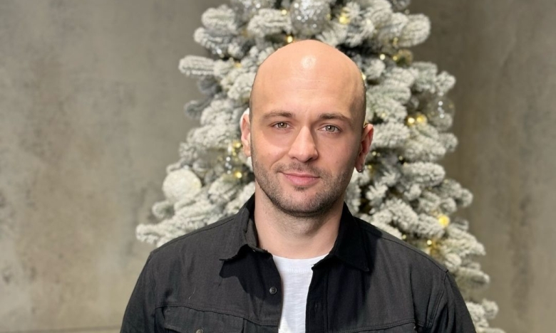 Співак Максим Бородін на фоні новорічної ялинки, фото