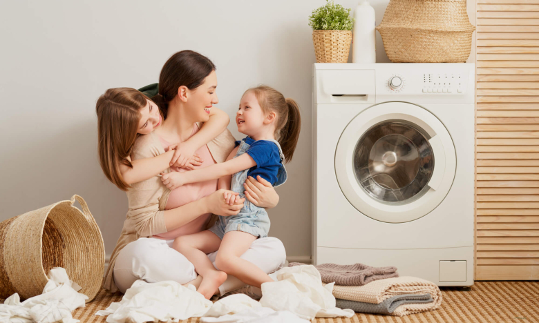 На фото женщина с детьми кладет вещи в машинку
